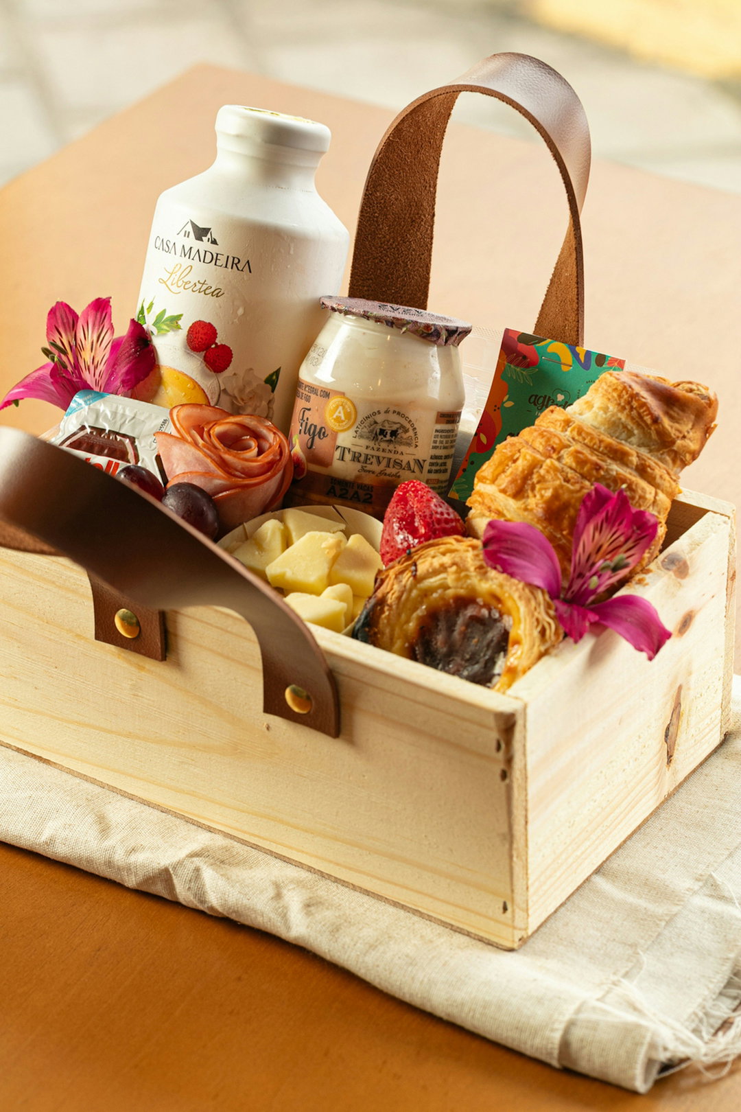 Wooden basket filled with breakfast items and flowers